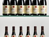 several bottles of wine are lined up on a glass shelf