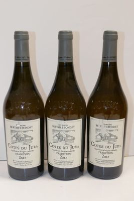trois bouteilles de vin sont alignées sur une surface blanche