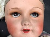 a close up of a doll with a flower on it ' s head