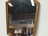 un miroir accroché au mur à côté d'une lampe