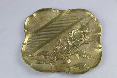 plaque en laiton ornée d'un motif de fleurs et de feuilles sur fond blanc