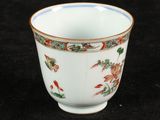 a white cup with red and green designs on it