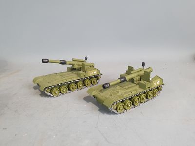 two toy army tanks sitting on top of a table next to each other