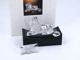 une figurine en cristal représentant un cheval, posée sur un socle noir