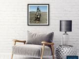 an image of a living room with a chair, lamp and a picture on the wall