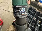 a person that is holding a green and black drill