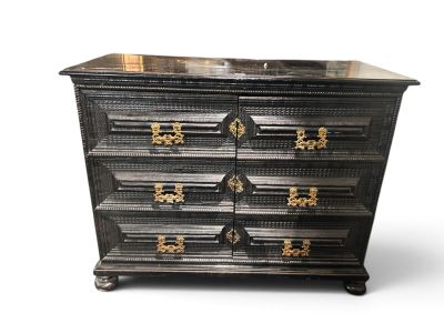 a black chest of drawers with gold hardware on the drawers