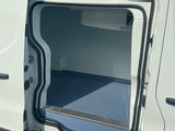 une camionnette blanche dont les portes sont ouvertes, garée sur un parking