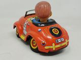 an orange toy car with a boy in the back