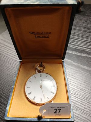 une horloge dans une boîte posée sur une table, avec une étiquette de prix