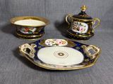 trois pièces de porcelaine ornées de motifs dorés et bleus