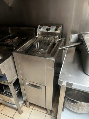 une photo d'une cuisine professionnelle équipée d'une friteuse et d'un évier