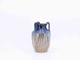 a blue vase that is sitting on a white surface