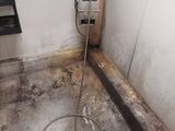une photo d'une salle de bains sale dans laquelle se trouve un tuyau d'arrosage