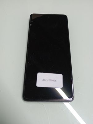 the back of a black cell phone sitting on top of a table