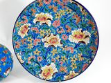 a blue plate and a blue bowl with flowers on it