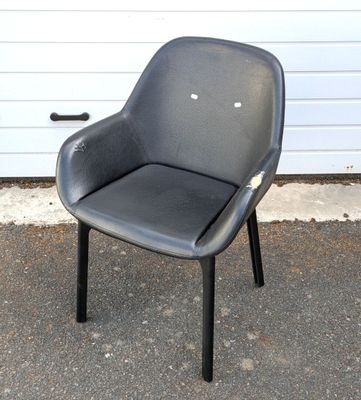a black chair sitting in front of a garage door