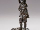 une statue en bronze représentant un homme coiffé d'un chapeau et accompagné d'un chien