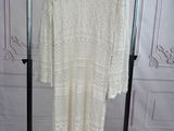 a white sweater dress hanging on a clothes rack in a room