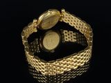 a close up of a gold watch on a black surface