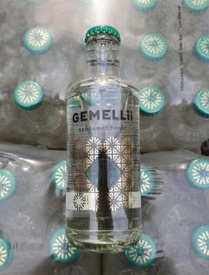 une bouteille de gin posée sur un lit
