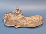 une image représentant une assiette en argent sur laquelle figure une dame
