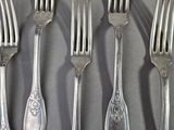 a lot of silver forks and spoons that are on a table