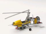 a small model of a yellow helicopter on a white surface