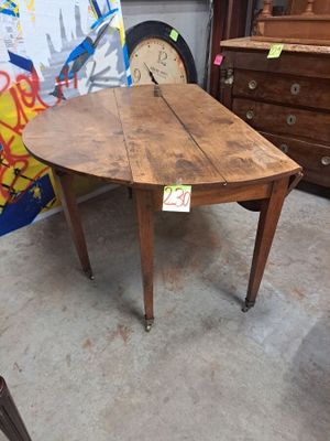 une table en bois sur laquelle se trouve une horloge, dans une pièce