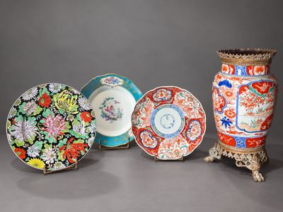 several plates and vases are lined up on a gray surface