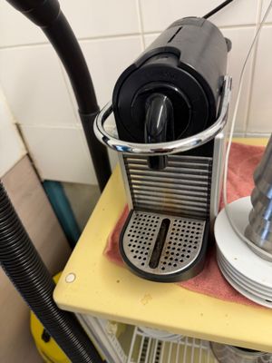 a coffee maker and a cup on a yellow shelf