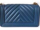a small blue bag with a chevron pattern on the front