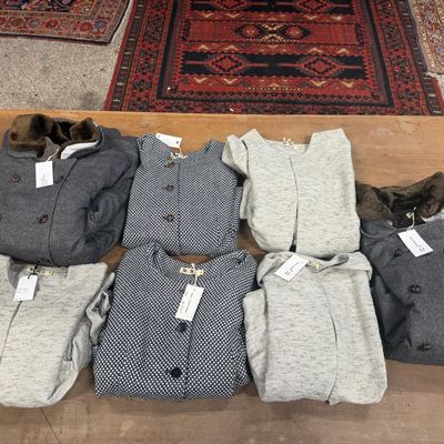 de nombreux vêtements posés par terre à côté d'un tapis