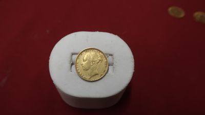 une pièce d'or posée sur une boîte blanche