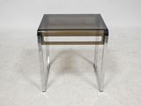 an image of a glass and chrome side table on a white floor