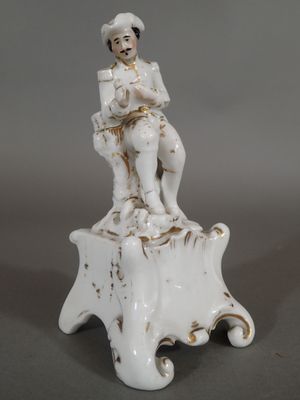 une figurine représentant un homme assis sur une souche d'arbre