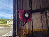 une borne d'incendie rouge accrochée au mur d'un immeuble