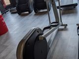 a gym room with a row of stationary exercise bikes