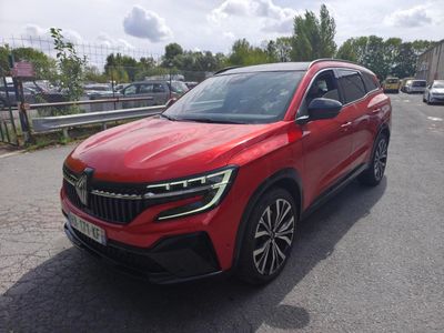 une voiture rouge garée sur le bord de la route