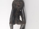 a wooden sculpture of a monkey hanging on a wall