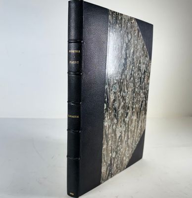a black book sitting on top of a table next to a white wall