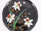 an image of a black plate with white flowers on it