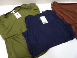 three t - shirts sitting on a table with tags on them