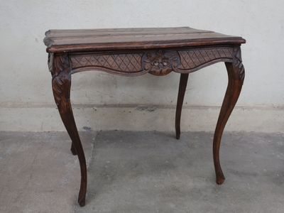a small table with a wooden top on a cement floor