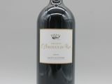 une bouteille de vin rouge posée sur une table blanche