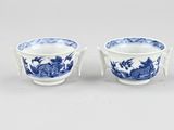 a pair of blue and white cups with dragon handles