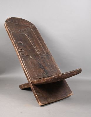 une vieille chaise en bois posée sur une surface blanche