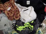 a pile of clothes that is sitting on a bed