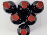six bottles of wine are arranged in a circle on a white surface