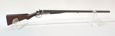 un vieux pistolet au canon en bois, posé sur un socle en acrylique transparent